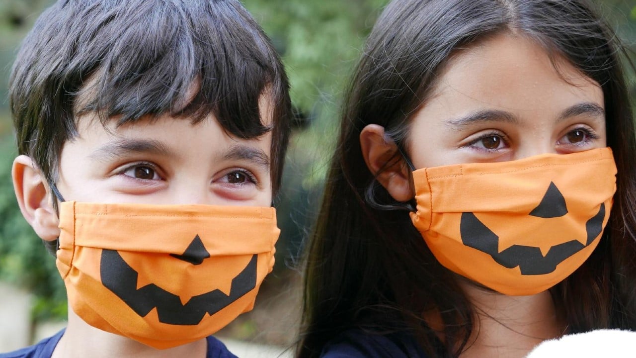 two young kids wearing pumpkin-style face masks